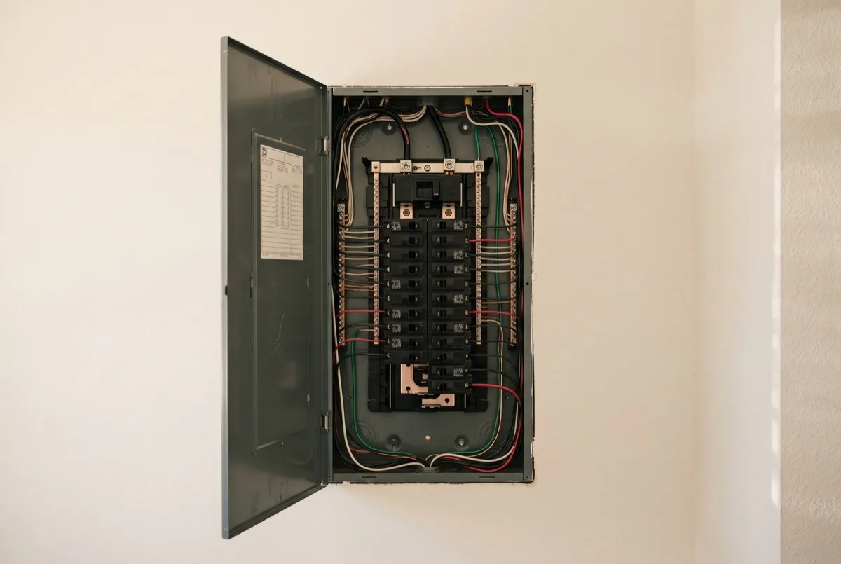 Open residential electrical panel with breakers
