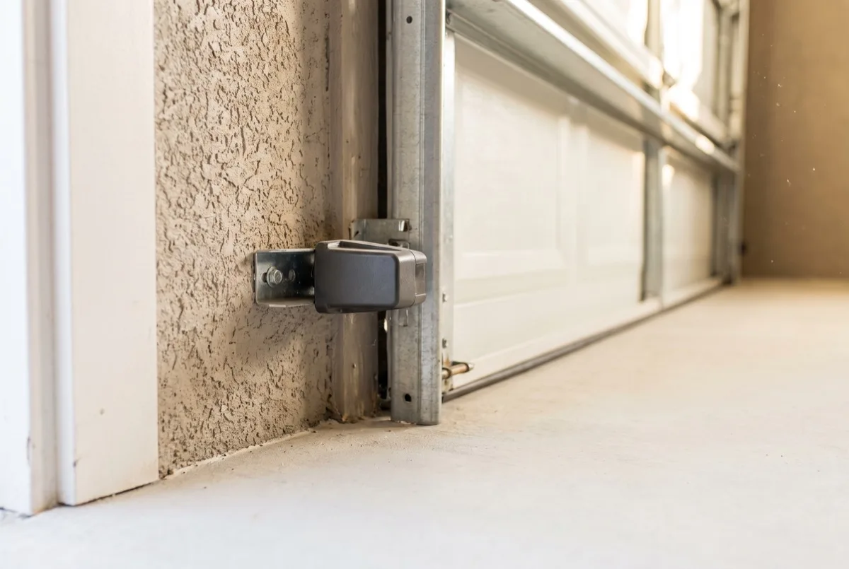 Safety sensor mounted near the floor of a garage door opening